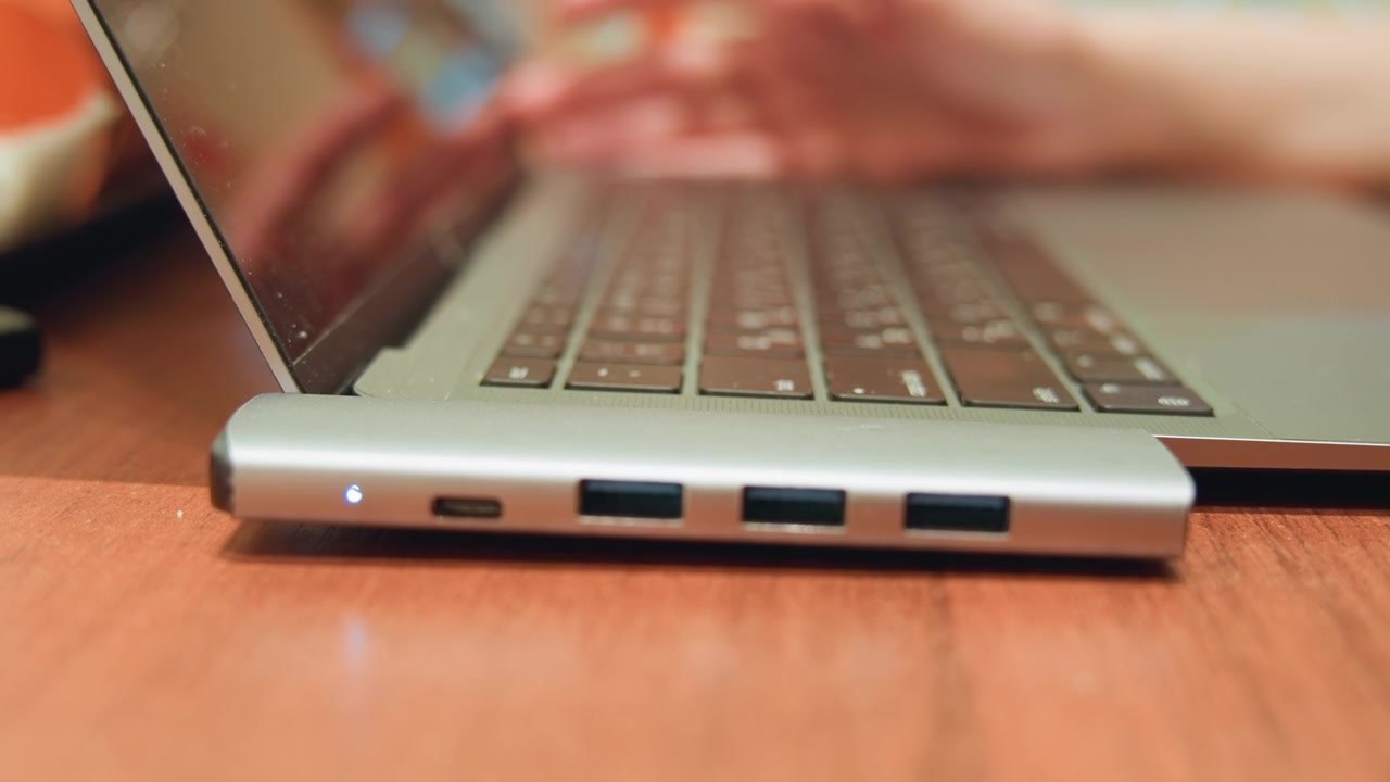 Primo piano di mani che coordinano periferiche. Vista dettagliata di mani che collegano dispositivi esterni al computer. Primo piano di mani che collegano attentamente più periferiche a un laptop durante una sessione di lavoro.
