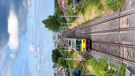 Urban-Journey:-Dart-Irish-Rail-Train-Departing-Kilbarrack-Station-on-a-Beautiful-Day---Vertical-Video