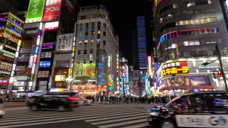 time-lapse of busy urban crosswalk with neon lights