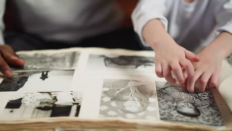 girl scratches photo of baby grandfather with father at home