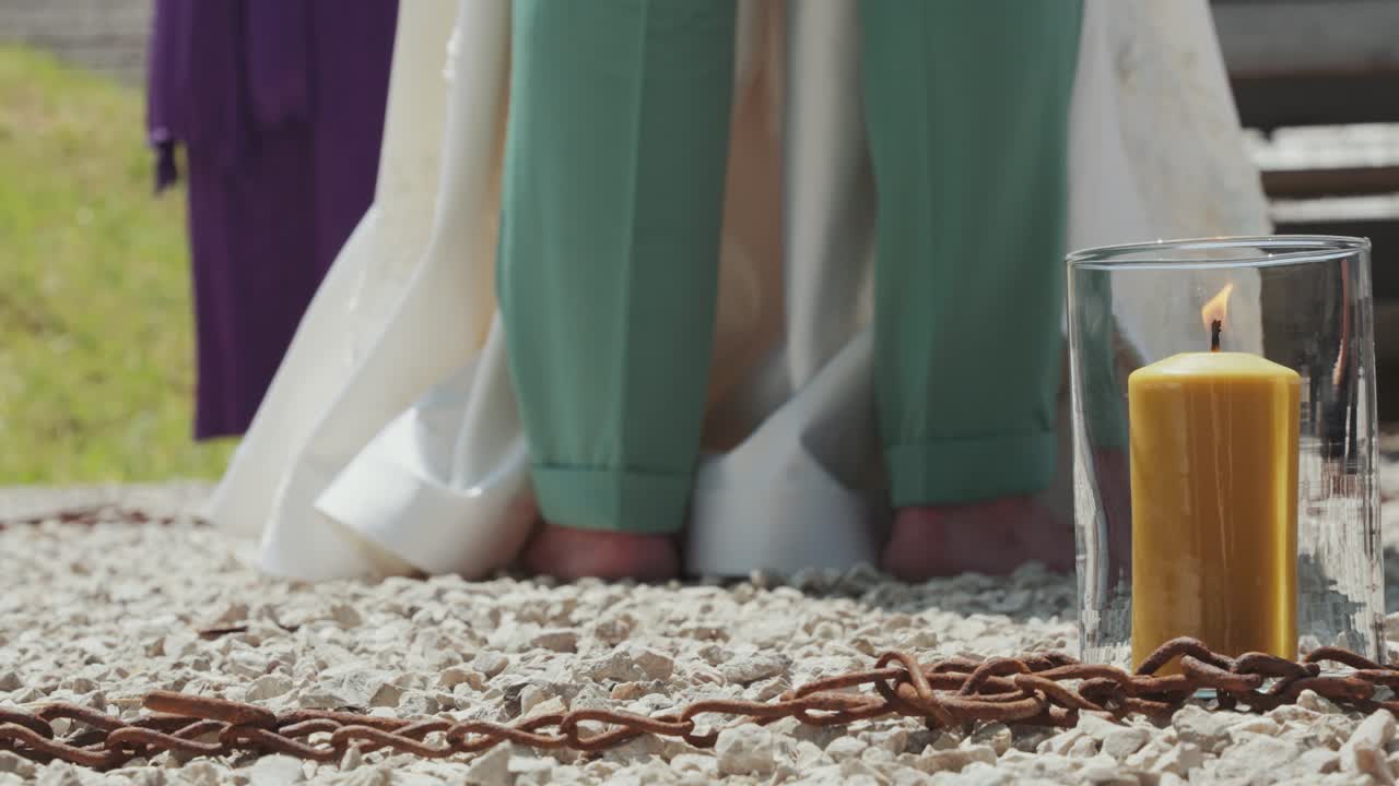 A barefoot bridal couple in a symbolic iron chain circle with a burning candle. Neo-Pagan ritual.