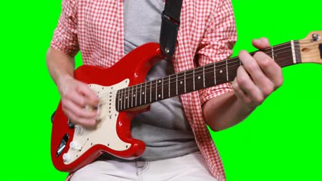 mid section of male musician playing guitar
