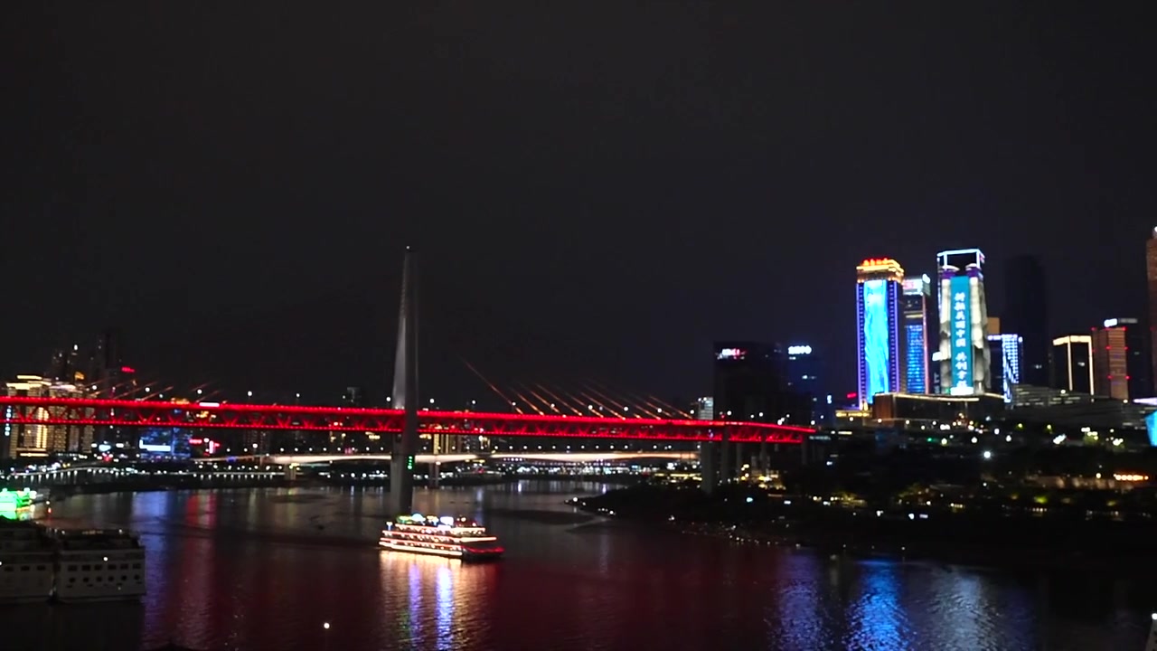Vista notturna del Ponte Qiansimen e del paesaggio urbano a Chongqing, Cina.