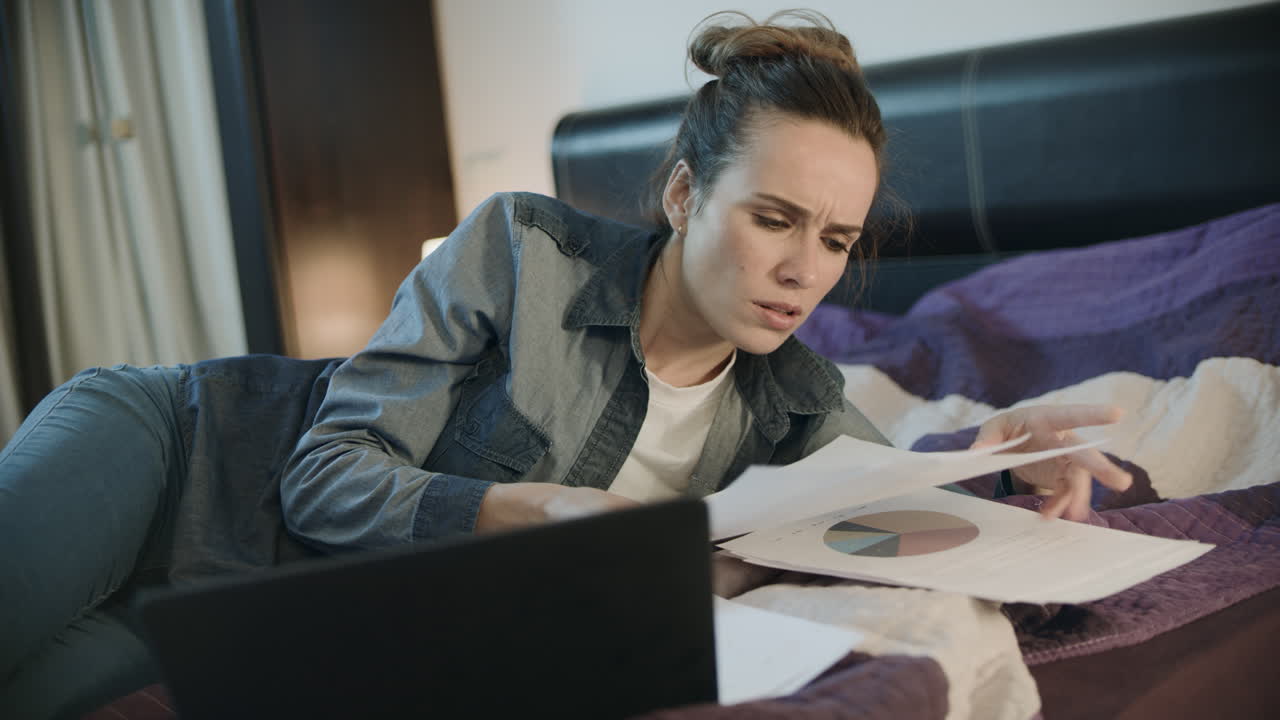 Thoughtful woman doing paperwork at night. Business woman working with papers