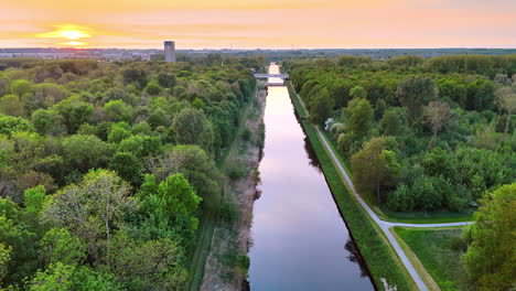beautiful sunset over dutch nature canal. a stunning sunset casts warm hues over a tranquil canal surrounded by lush greenery in the netherlands