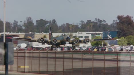 a vintage airplane takes off from an airport