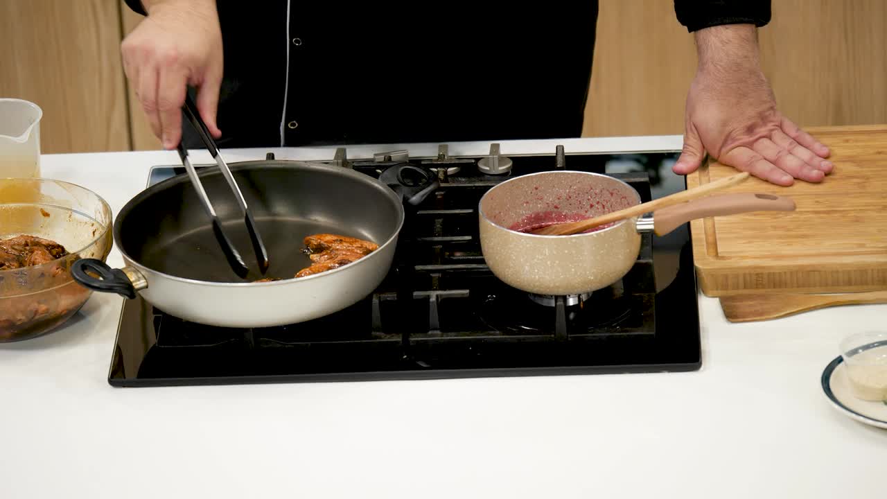 This cooking tutorial showcases the process of pan-searing chicken while simultaneously preparing a berry sauce on a stovetop. Step-by-step instructions are provided for an easy meal