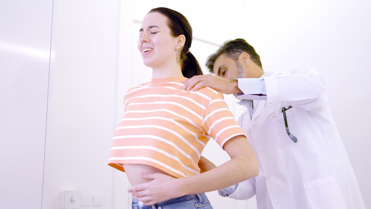 Woman complaining about back pain in a clinic