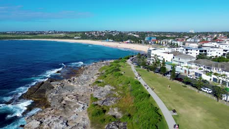 drone aerial landscape pan maroubra beach people on walkway pathway street residential housing activities headland coast sydney travel tourism australia