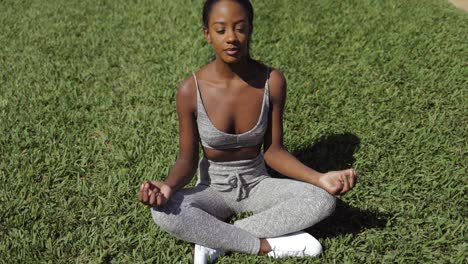 Schwarze-Frau,-Die-Auf-Rasen-Meditiert