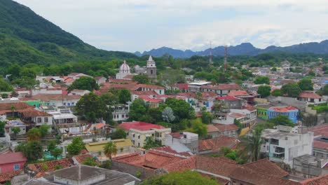 Aerial-dolly-zoom-of-vibrant-city-nestled-in-lush-green-mountains