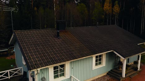 AERIAL:-Inspector-drone-checking-the-condition-of-a-dirty-house-roof,-fall-day