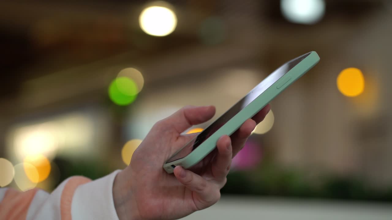 centrarse en la mano femenina usando el teléfono inteligente y publicando en las redes sociales.