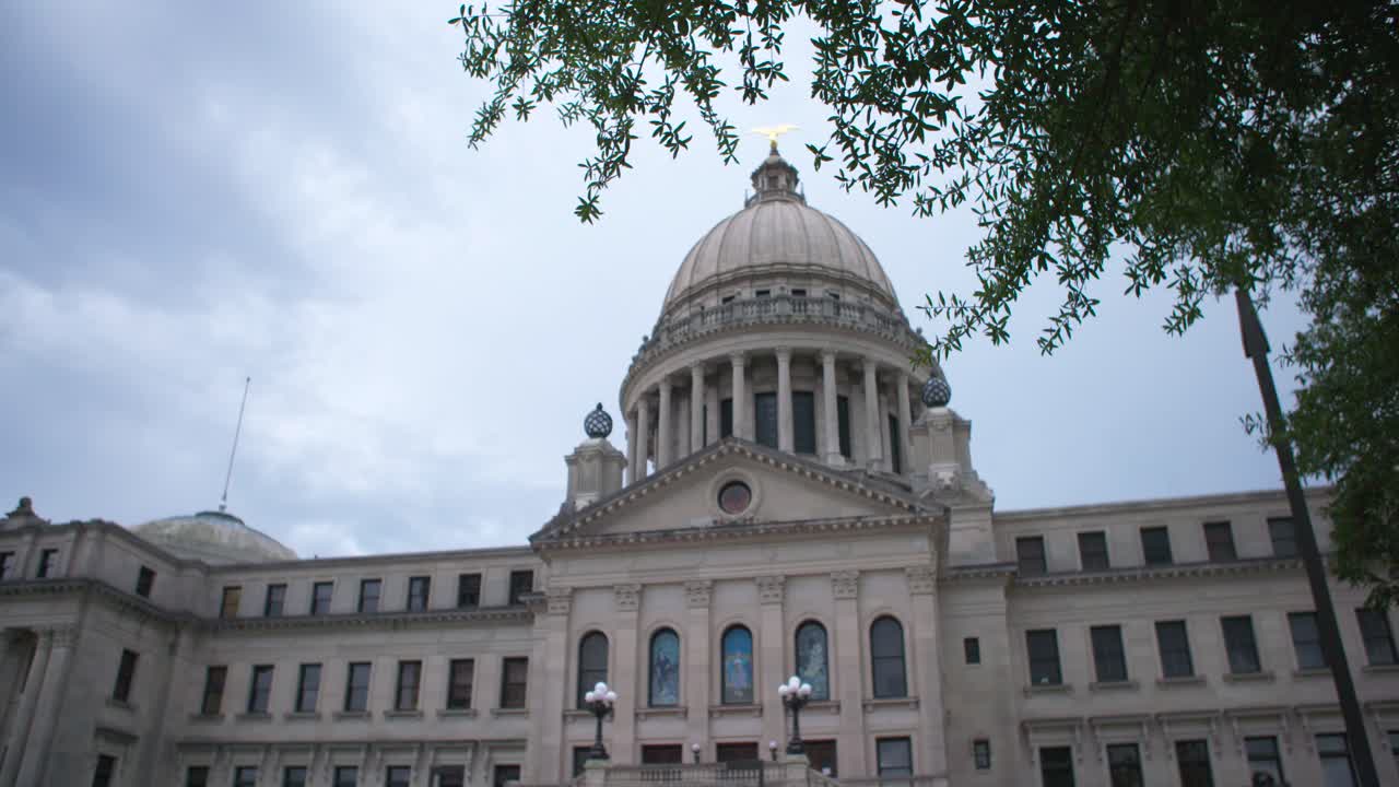 Rack focus, wide: Stormy skies over the Mississippi State Capitol building. Jackson, MS