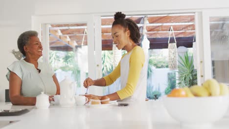 Afroamerikanische-Mutter-Und-Tochter-Lächeln,-Während-Sie-Zu-Hause-Gemeinsam-Kaffee-Trinken