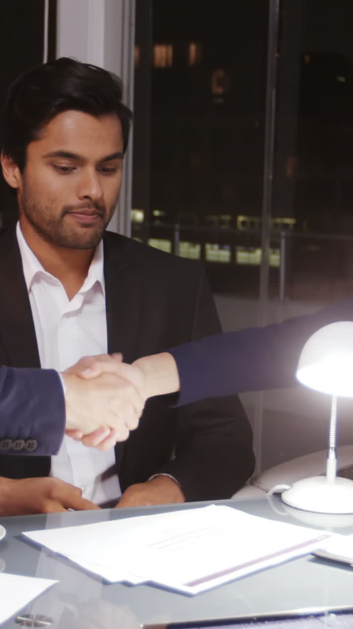 Affärsfolk skakar hand på kontoret