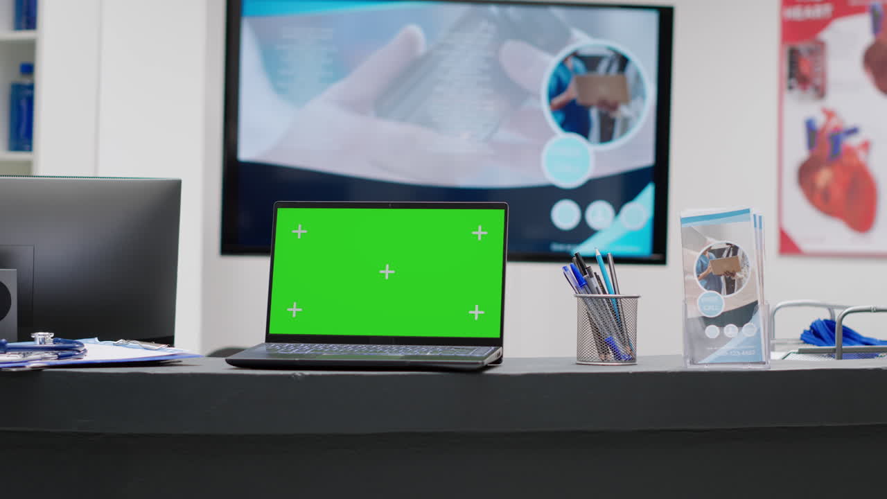 Laptop with green screen on a desk in an office