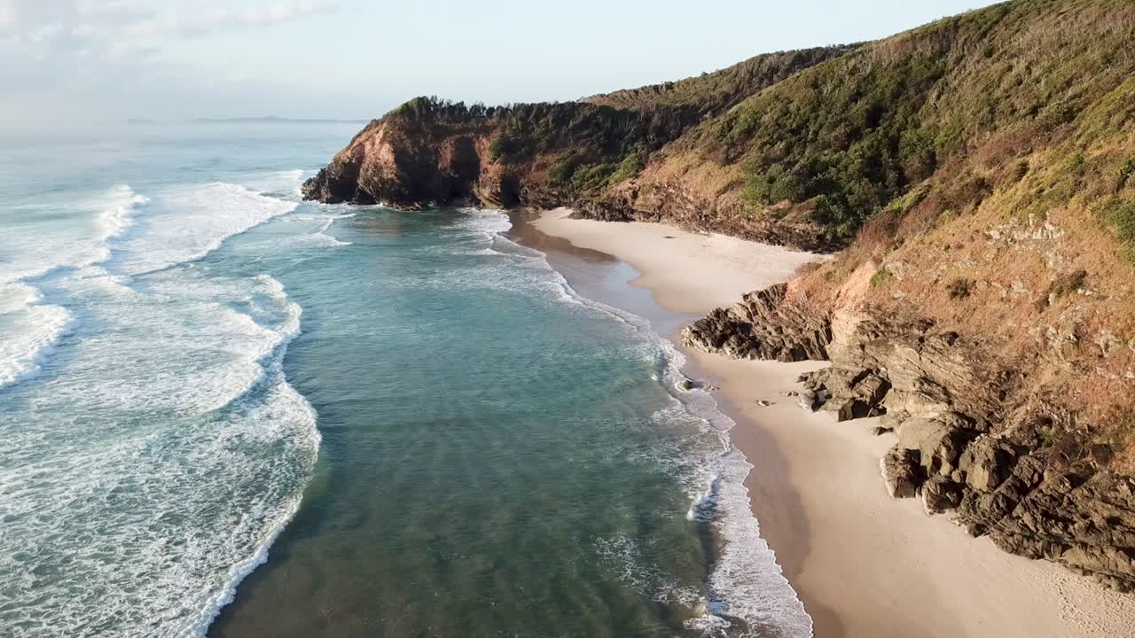 medium tilting up drone shot of beaches and cliffs at Byron Bay Australia