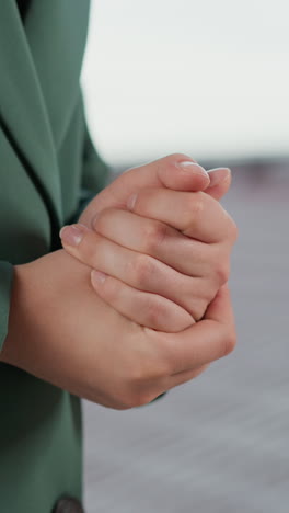 Nervous woman rubs hands on roof closeup. Businessperson worried by stressful situation at workplace on rooftop. Lady scared by career obstacles