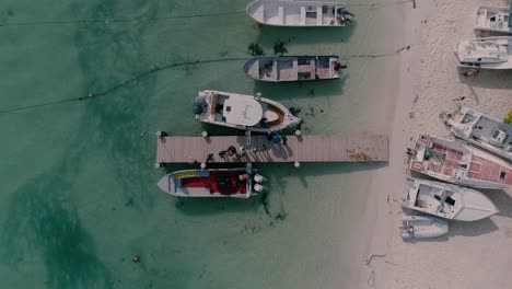 Vista-Superior-La-Gente-Se-Para-En-El-Muelle-De-Madera-Sube-A-La-Lancha-Motora,-Los-Roques-Venezuela