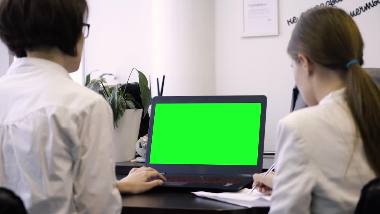 녹색 화면으로 노트북을 사용하는 의사들