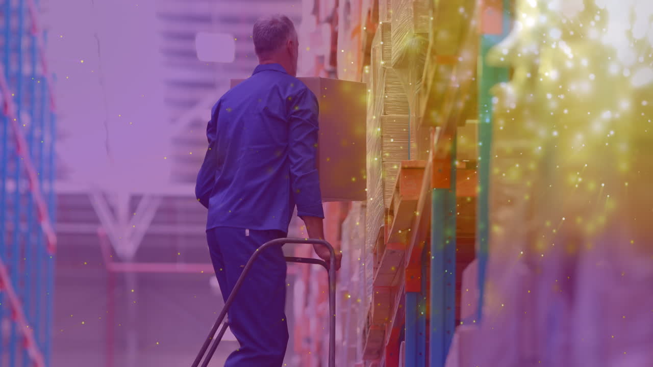 animación de puntos brillantes de luz sobre un hombre caucásico que lleva una caja trabajando en un almacén,
