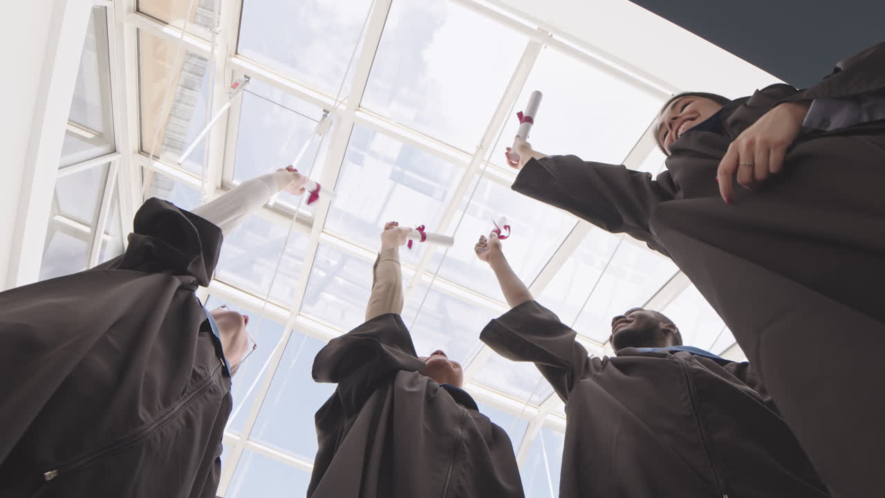 Four Happy Diverse Graduates with Diplomas