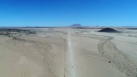 aerial of a jeep driving to spitzkoppe in nambia surrounded by desert.