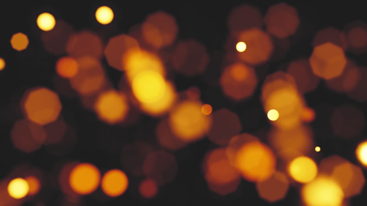 Luci bokeh arancioni calde scintillanti su sfondo scuro
