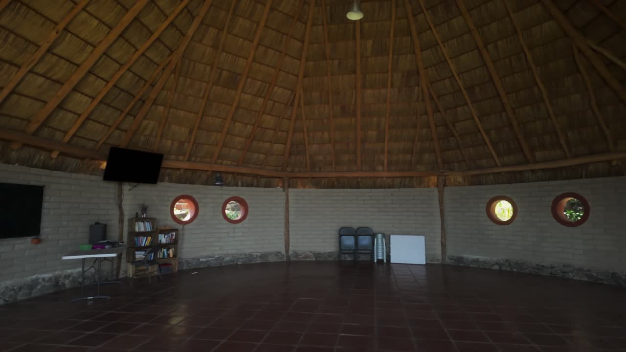 A Cozy Interior of a Thatched-roof Hut With Circular Windows - Pan Right Shot