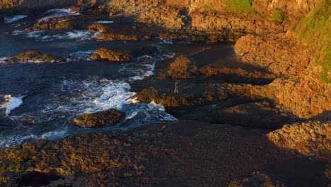 Person,-Die-Auf-Vulkanausbrüchen-An-Der-Felsigen-Küste-Bei-Cathedral-Rocks-In-Der-Nähe-Von-Jones-Beach-In-Kiama-Downs,-NSW,-Australien,-Steht