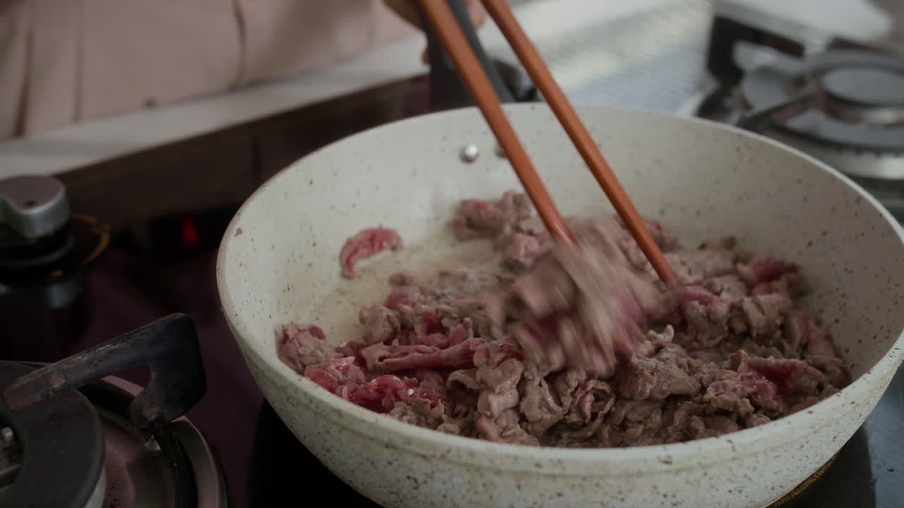 Tangan Wanita Memasak Daging di Wajan di Rumah