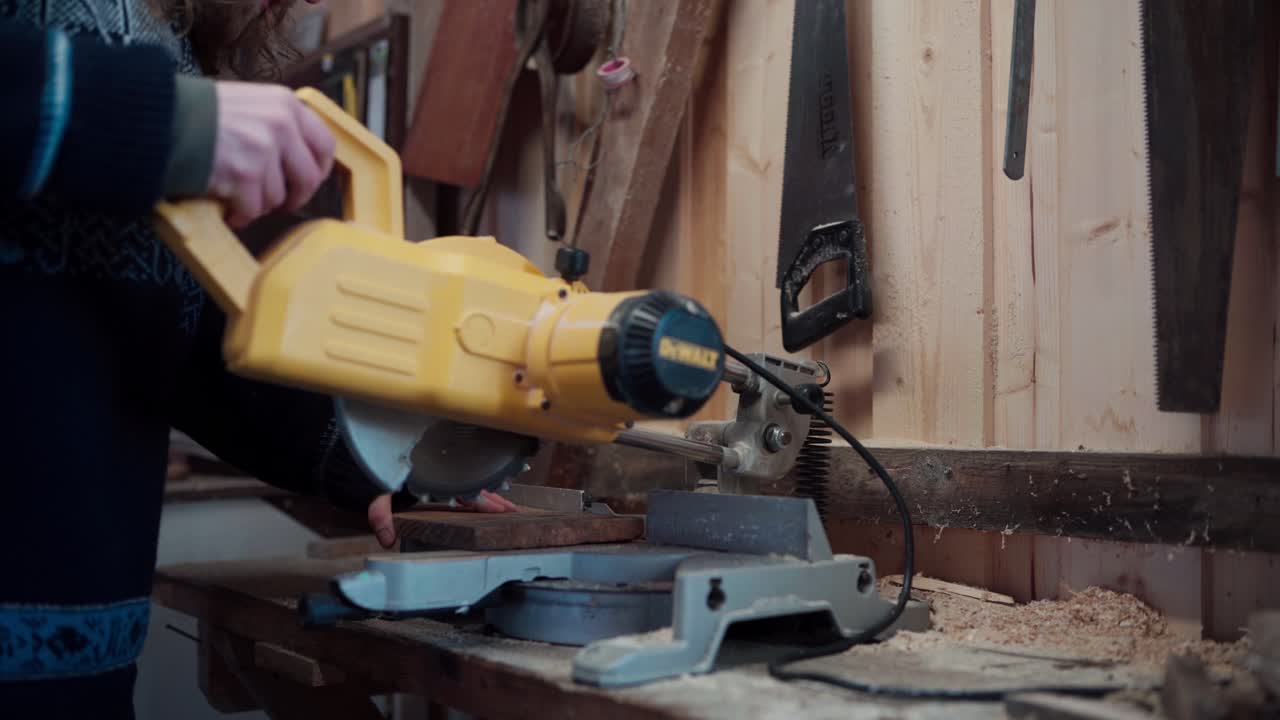el hombre está cortando una tabla de madera con una sierra circular para la construcción de una bañera de baño caliente diy - de cerca