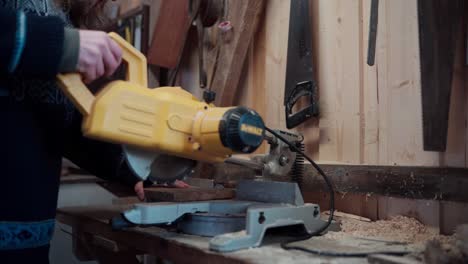 el hombre está cortando una tabla de madera con una sierra circular para la construcción de una bañera de baño caliente diy - de cerca