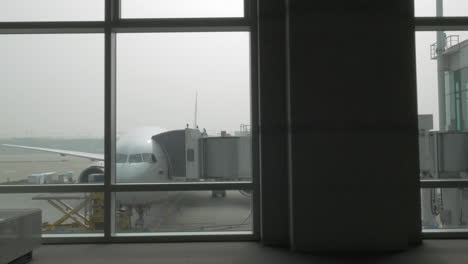 unloading the plane with attached air bridge view from the window