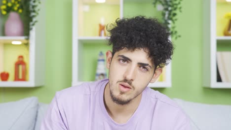 Young-man-looking-at-camera,-listening-with-focus-and-laughing.