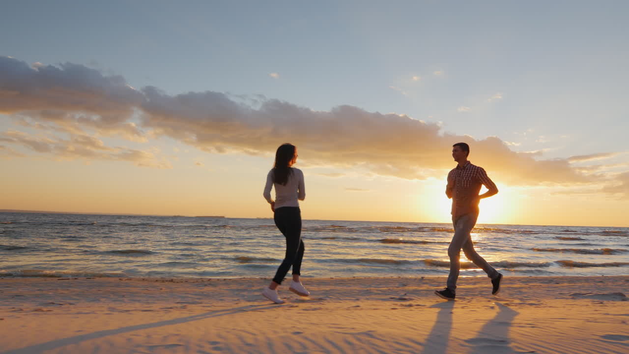 일몰 베루게구 남자가 해변에서 즐거운 시간을 보내는 사랑에 빠진 커플 - 더 혼