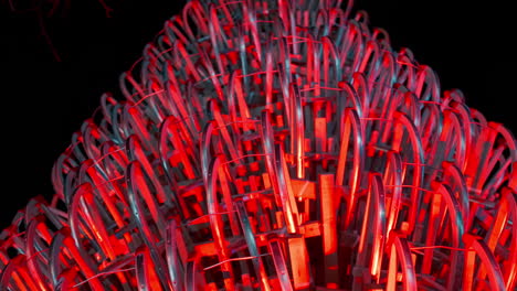 gran árbol de navidad hecho de trineos iluminado con luces rojas durante una noche en un campus universitario del mercado de navidad en viena, austria