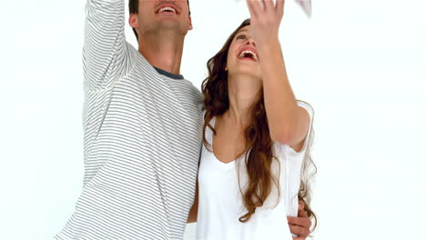 una pareja feliz arrojando dinero.