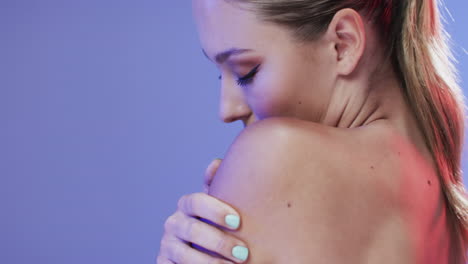 caucasian woman with blond hair and make up touching her shoulder, copy space, slow motion