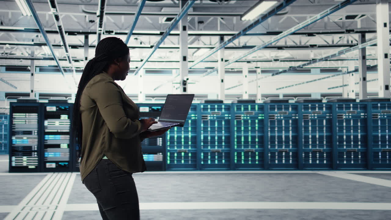 Data center worker using laptop to manage software updates for system stability