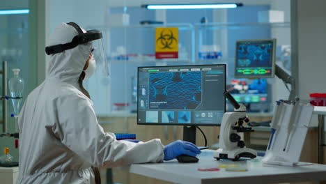 hombre científico trabajando en el desarrollo de la vacuna escribiendo en la computadora en su camiseta