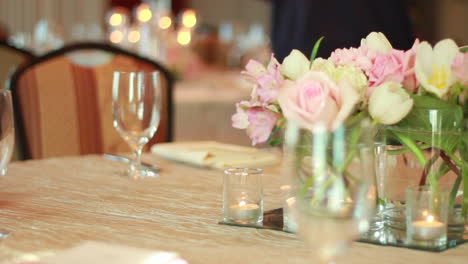 Schöne-Blumen-Auf-Einem-Hochzeitstisch-Mit-Einem-Rack-Fokus-Auf-Schöne-Kerzen