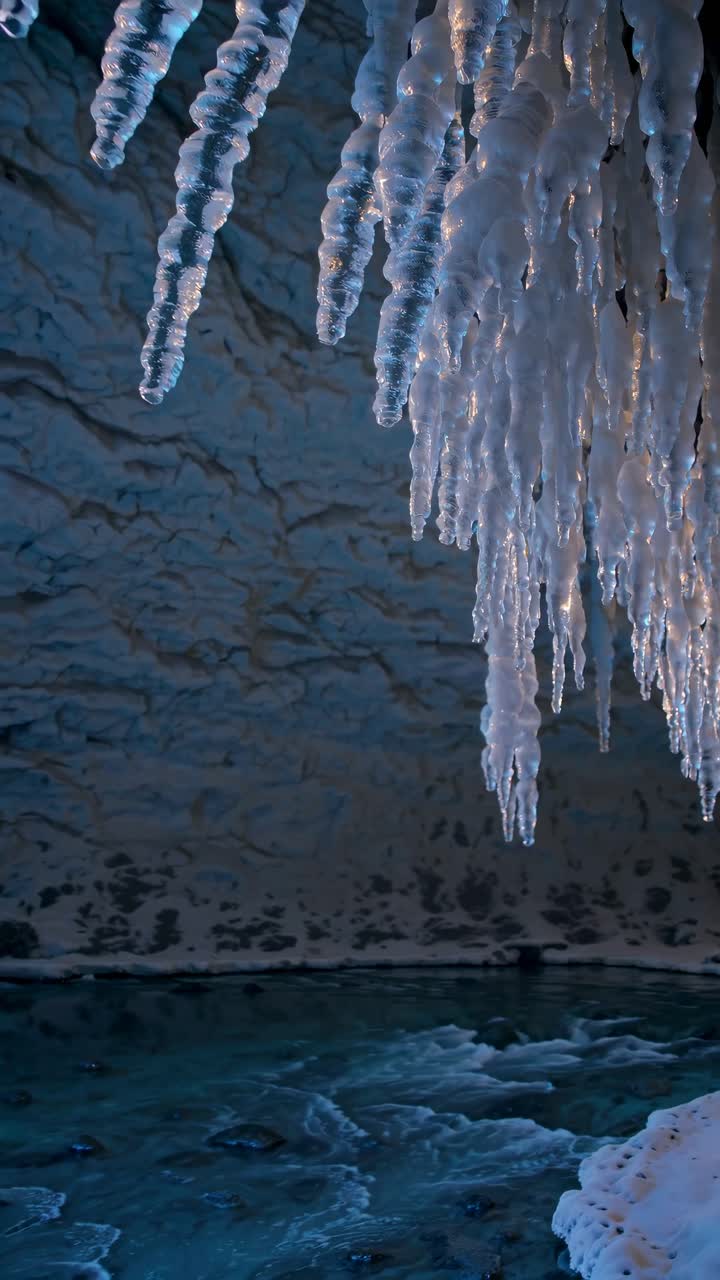 Foto em ângulo baixo de estalactites penduradas em uma caverna, capturando uma atmosfera invernal serena