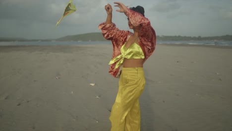 a professional, beautifully composed image showcases a young asian model, gracefully attired in a vibrant yellow ensemble, reveling in the joy of flying her kite on a picturesque beachside location