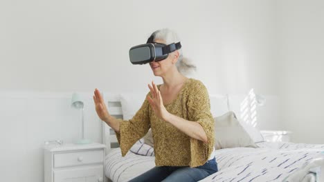 mujer caucásica mayor que usa auriculares vr y se divierte