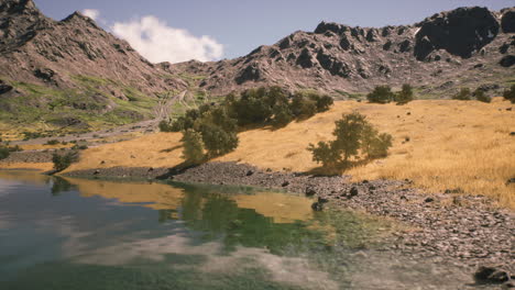 vista panorámica de un río tranquilo que refleja las montañas a la luz del día brillante