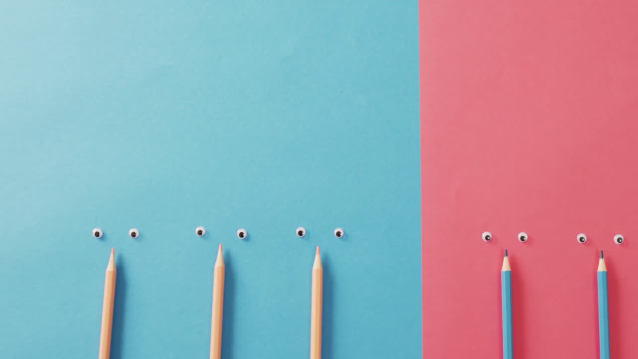video de composición con lápices de colores y ojos en superficie azul y rosa