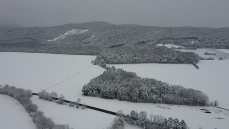 drone flies high over winter landscape with mountains with snow