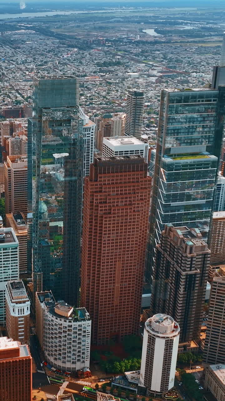 Top view on Philadelphia group of skyscrapers at daytime. Vast cityscape limited by the rivers at backdrop. Vertical video
